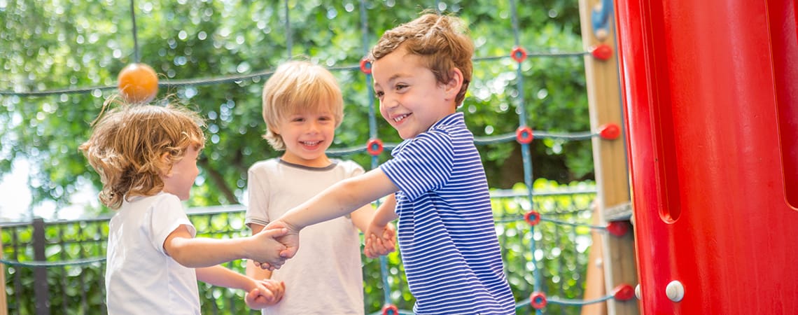 Three kids play on the playground