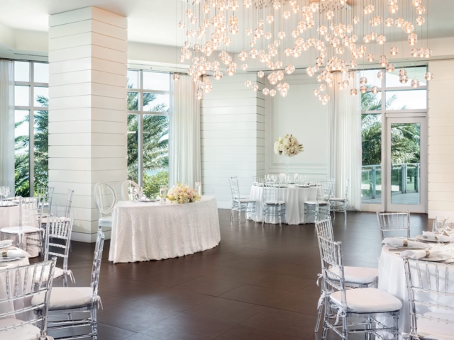 A large room with tables with white tablecloths