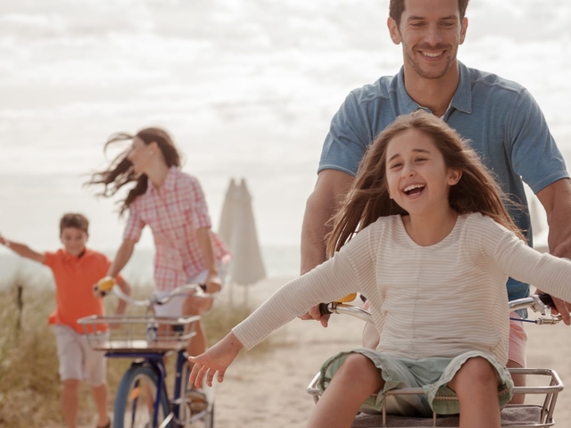 A family biking down the beach