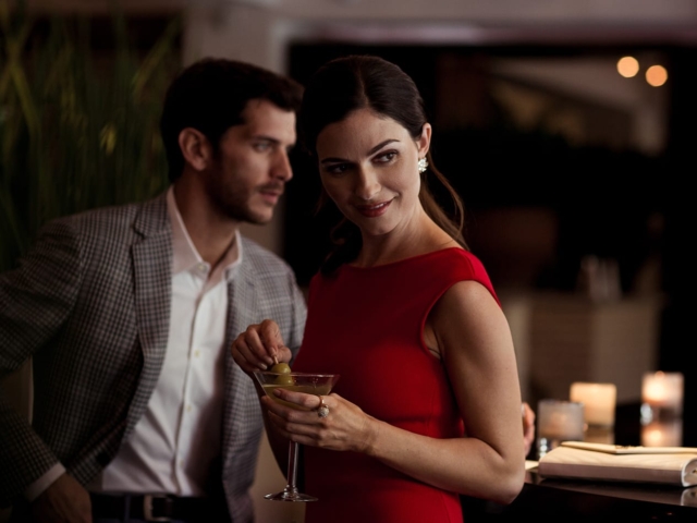 A woman drinks a martini